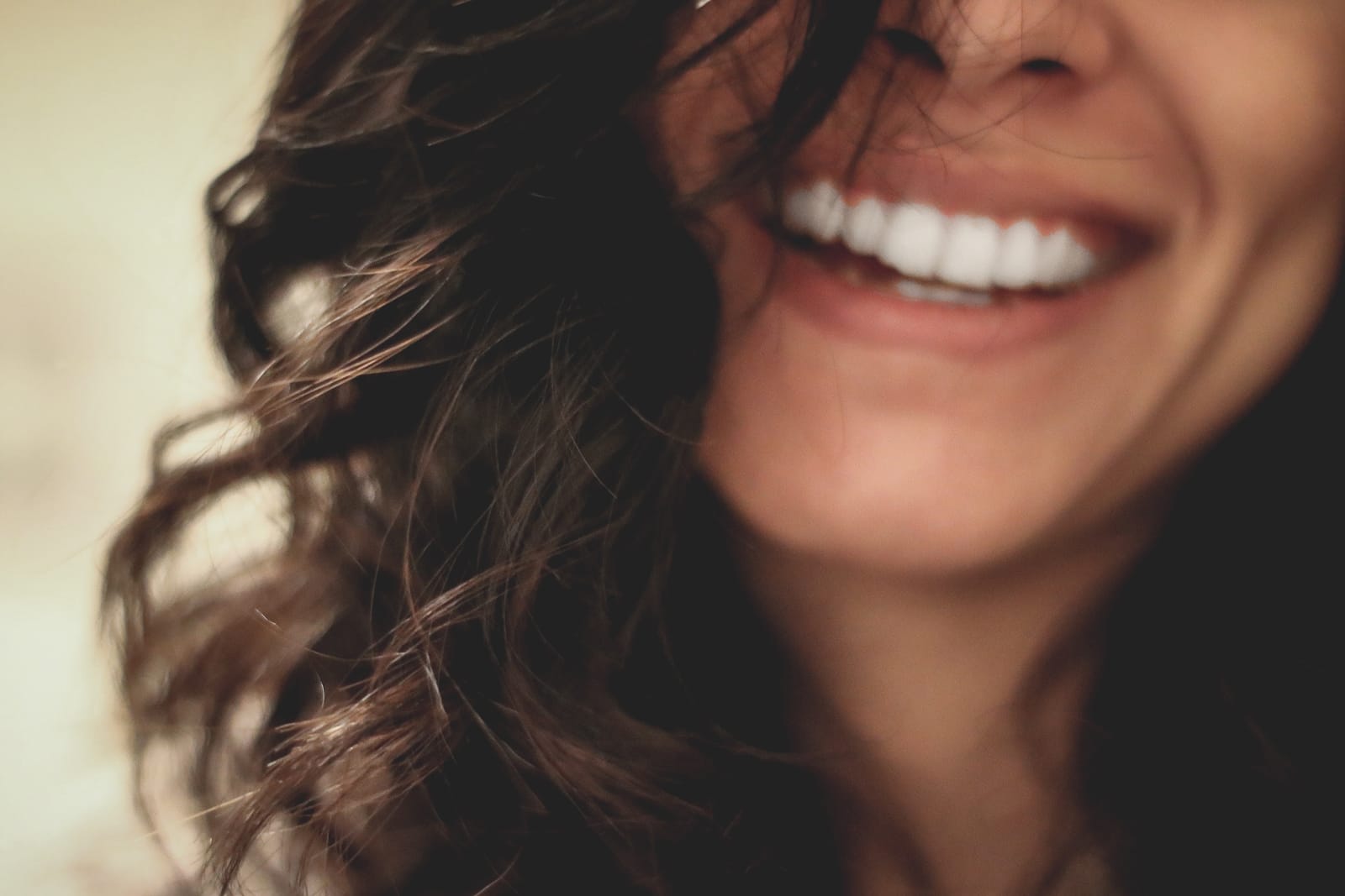 Image of a woman smiling, showing only her teeth